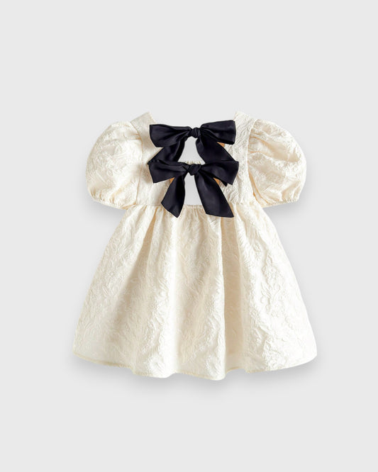 Cream jacquard baby dress with puff sleeves and dark back bows