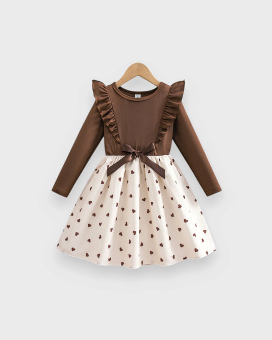 Brown ribbed long-sleeve baby dress with shoulder ruffles, waist bow and cream heart-print skirt.