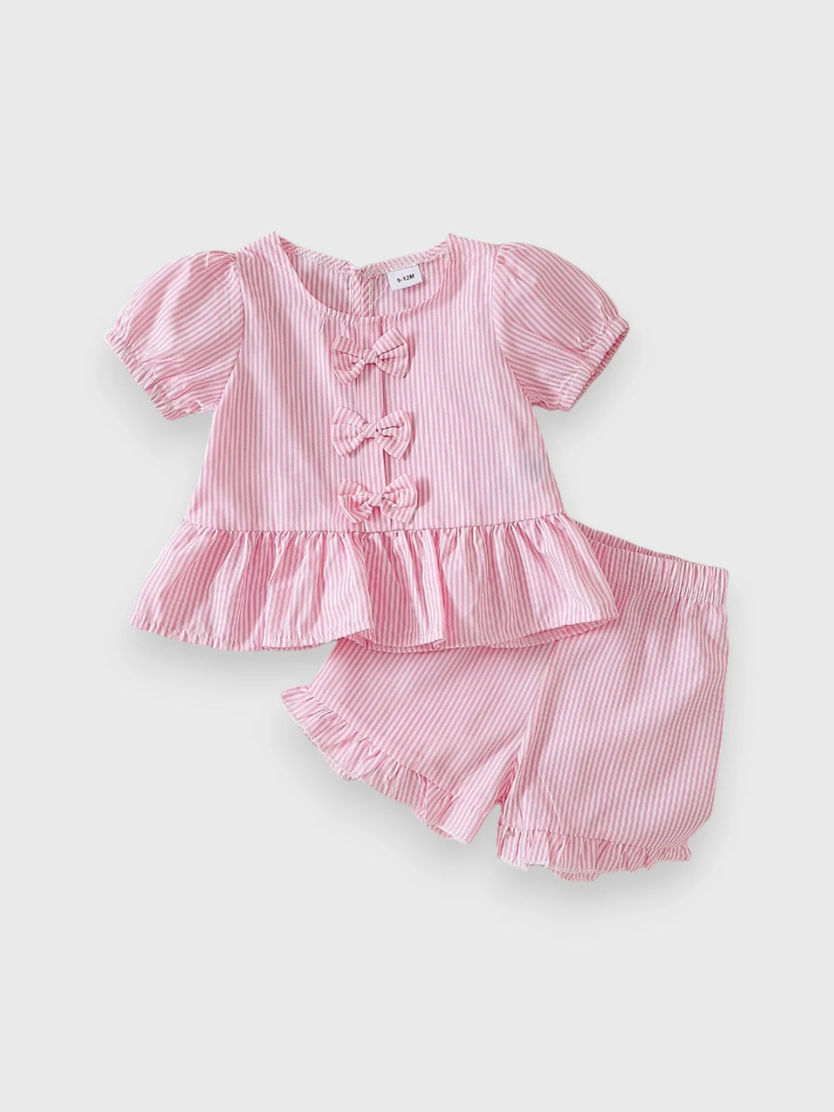 Pink peplum puff-sleeve top with bow details and matching shorts