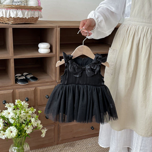 Black baby girls' tulle romper dress with large bows on the bodice, held on a hanger.